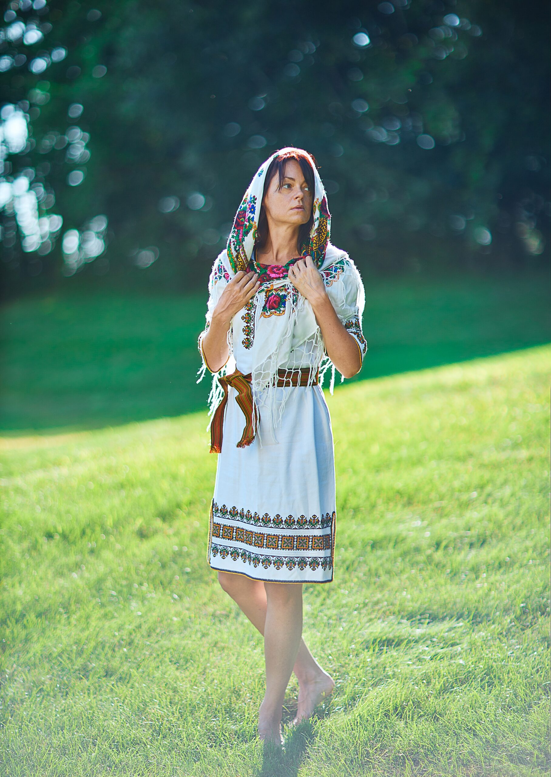 European woman with Ukrainian outfit standing on grass