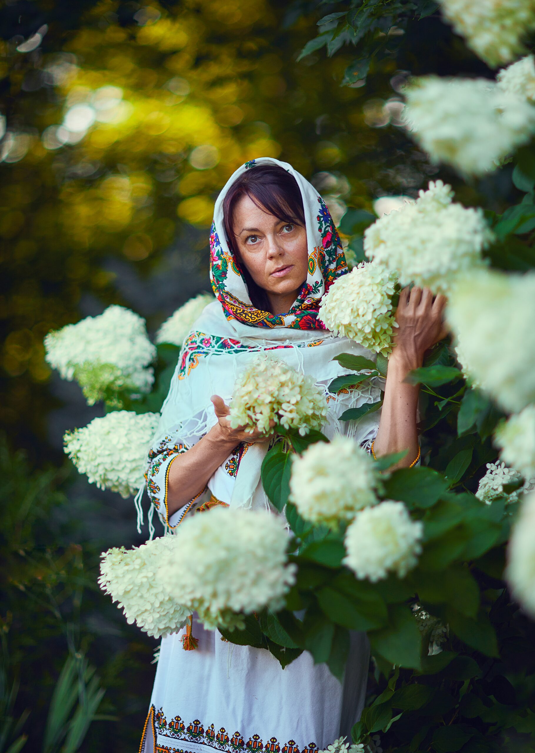 European woman standing in flowers