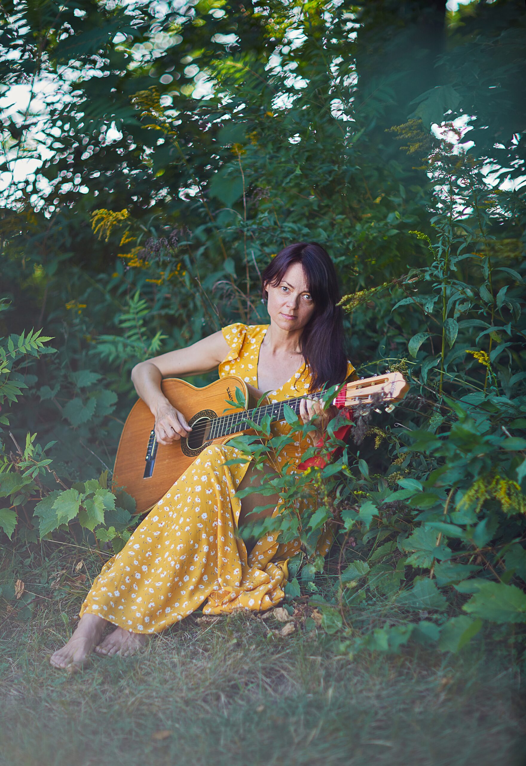 woman playing guitar In sun dress