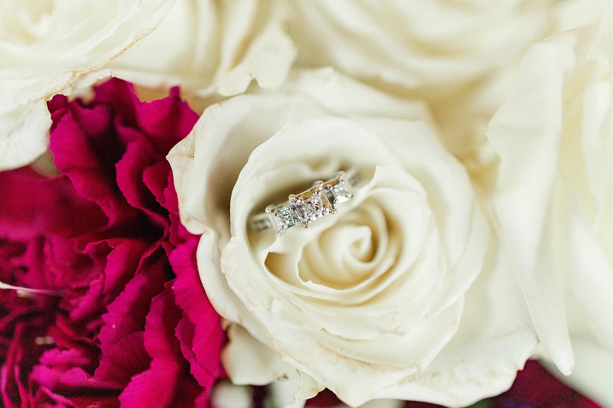 white and red flower with engagement ring 