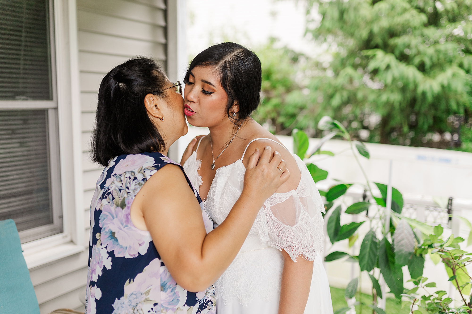 mother of bride giving a kiss to her daughter 