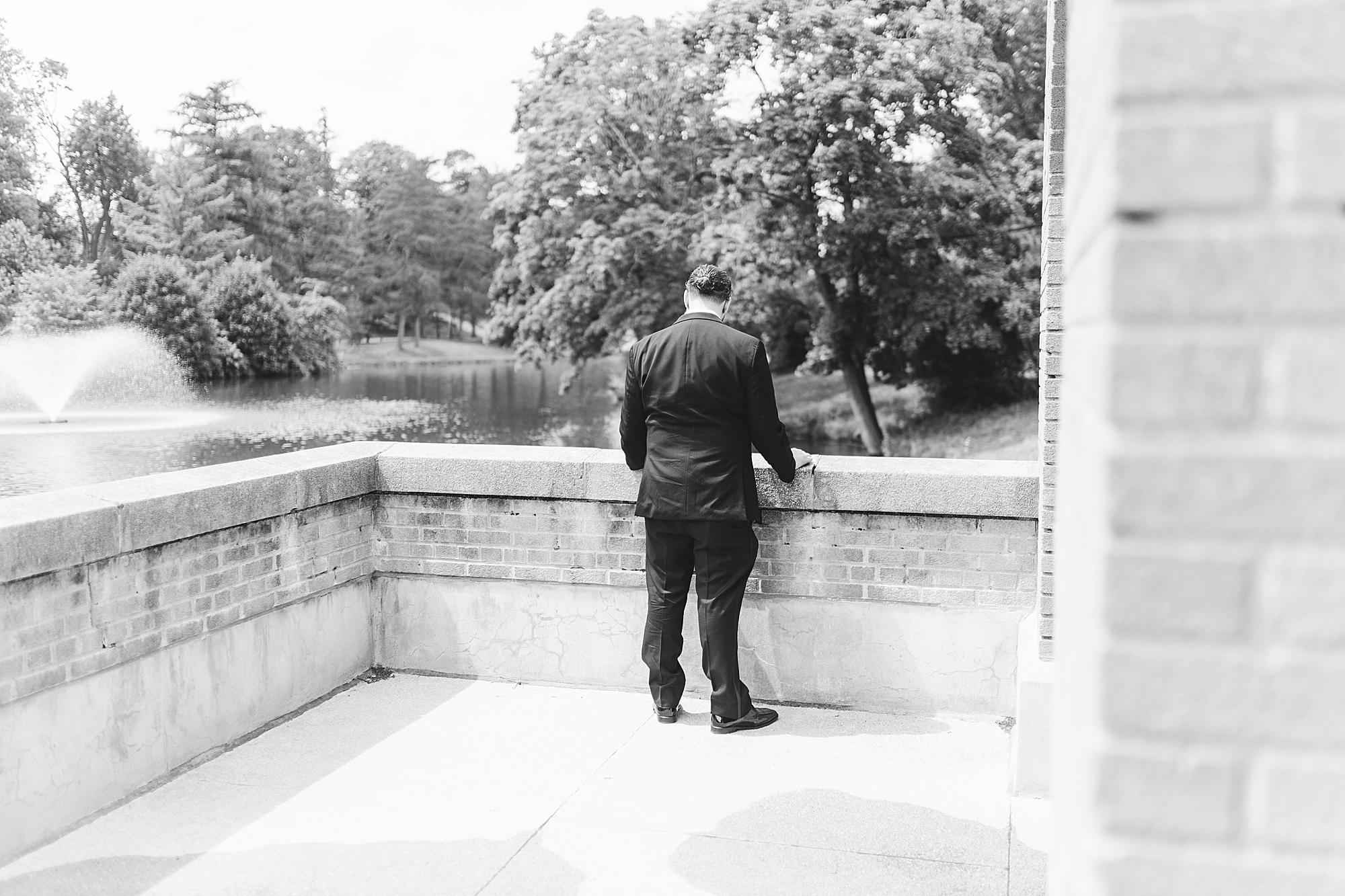 groom waiting outside on patio looking at the water