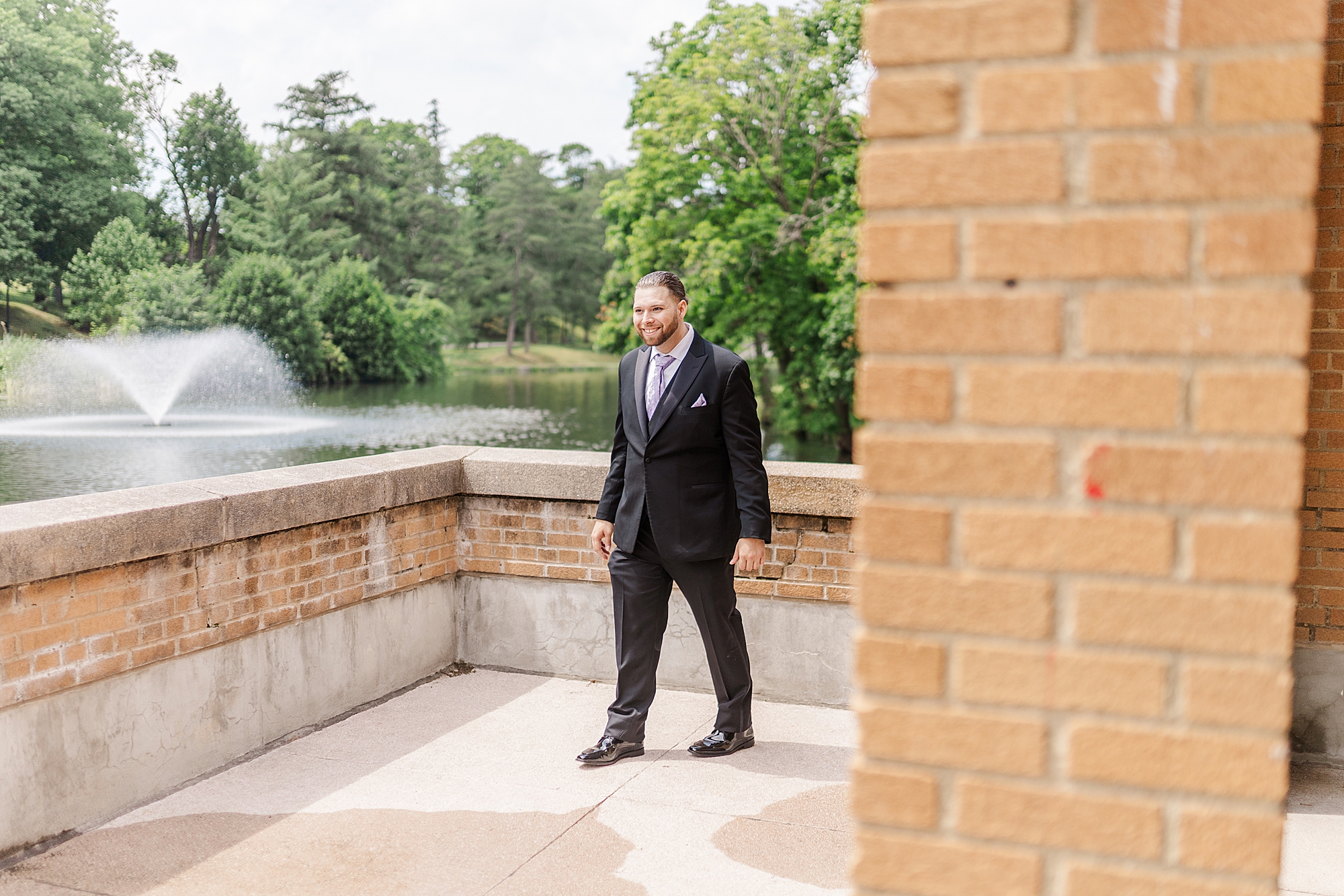 groom on outdoor patio near lake 