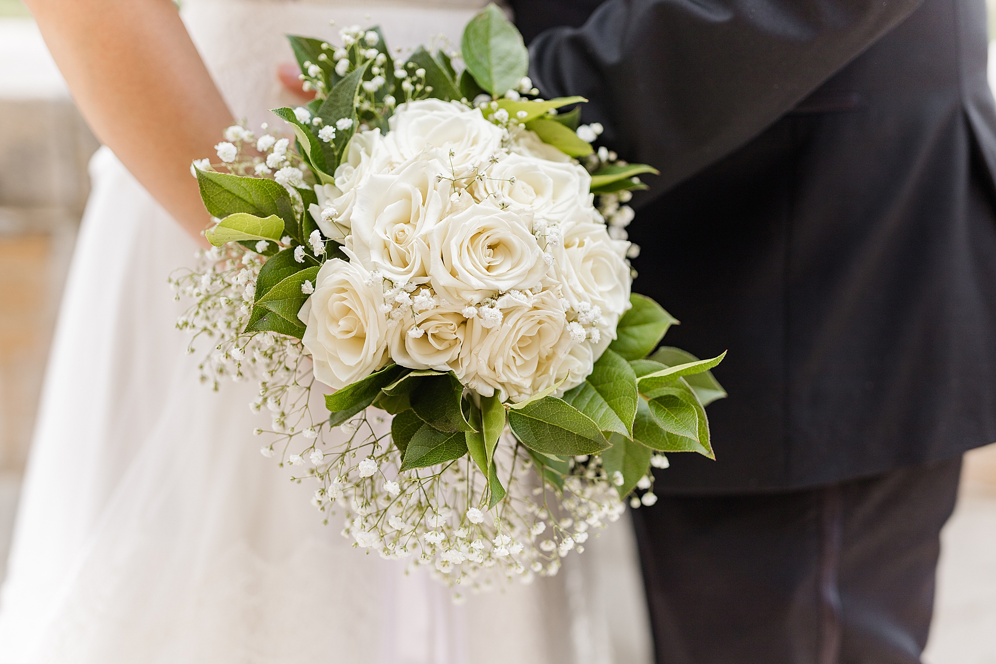 bride holding bouquet of white flowers and baby's breath 