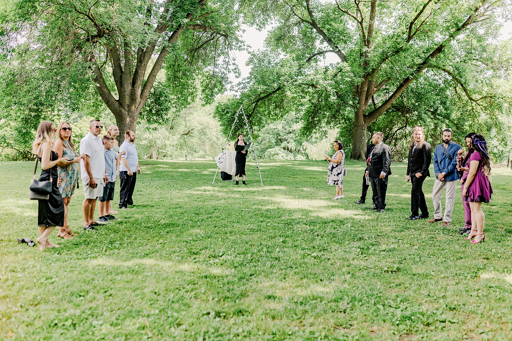 wedding guests and outdoor wedding ceremony in park 