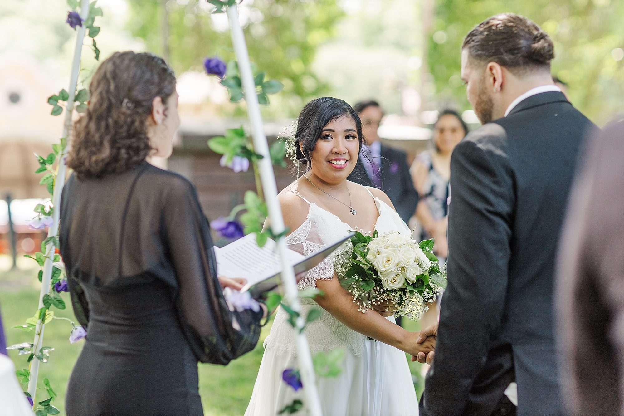 bride holding hands with groom holding bouquet of flowers