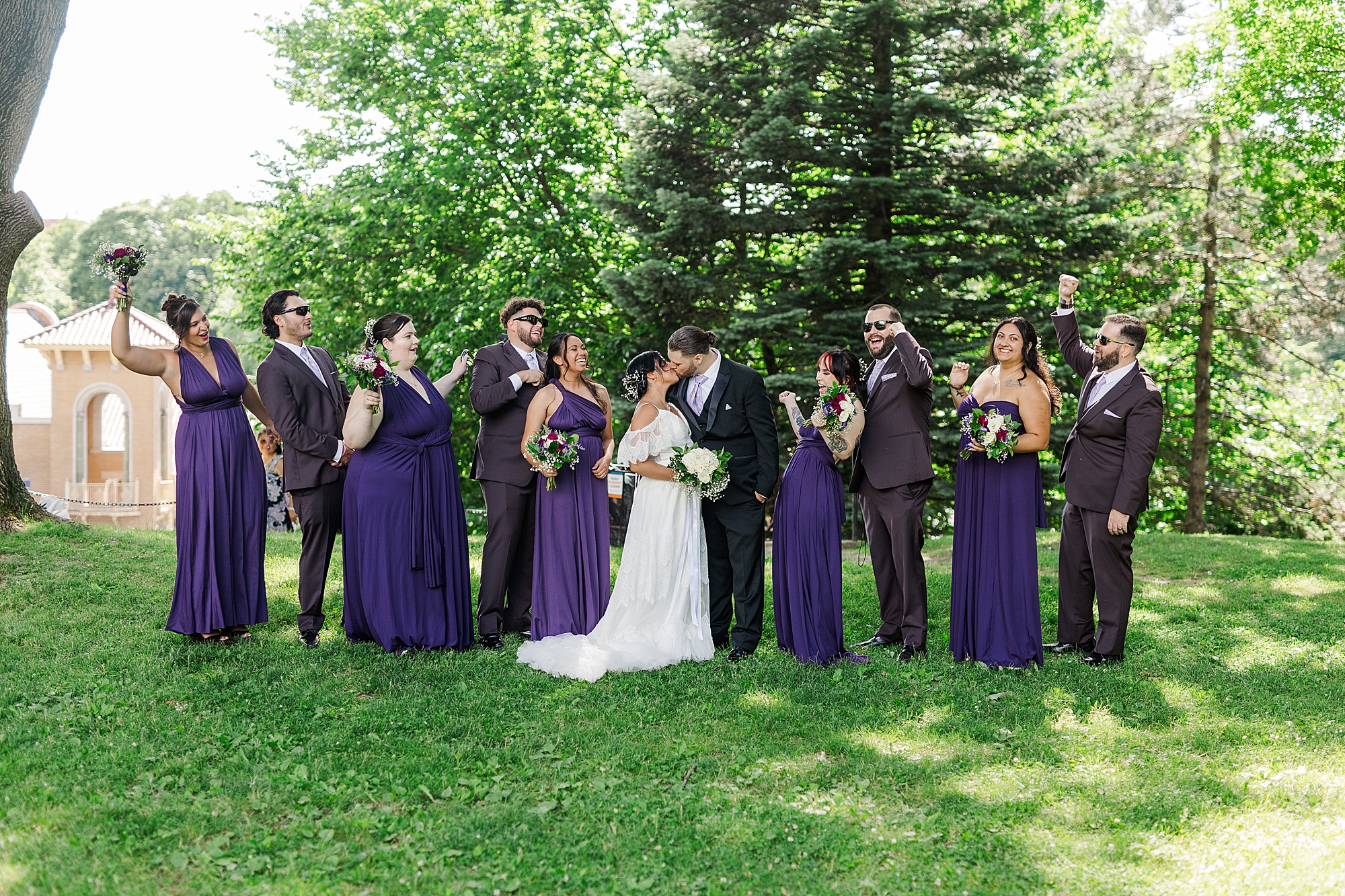 bridal party cheering for bride and groom in park 