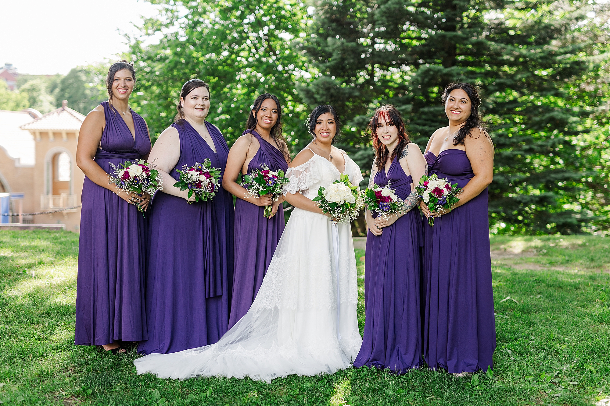 bridesmaids with bouquets in park 