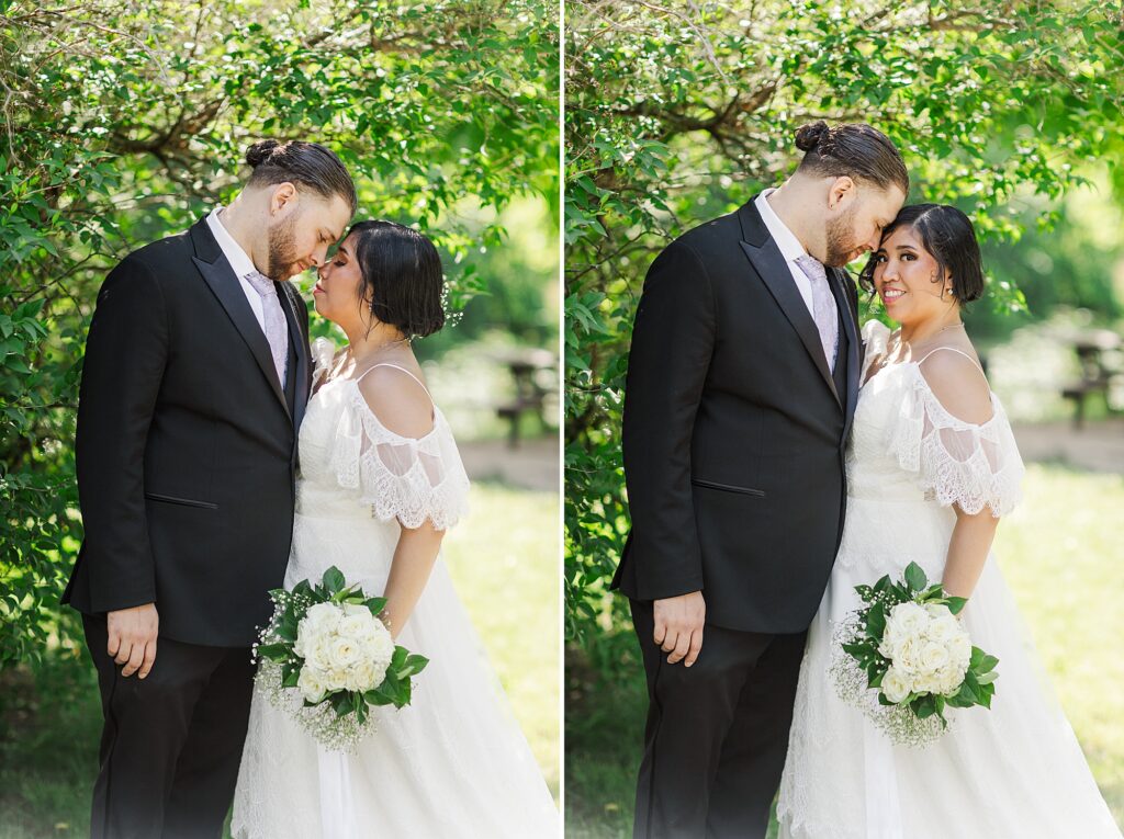 bride and groom standing underneath a tree in a park 