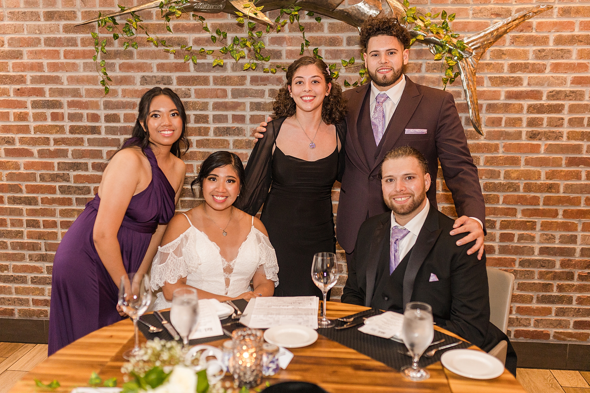 bride and groom at dinner with maid of honor, best man and officiant 