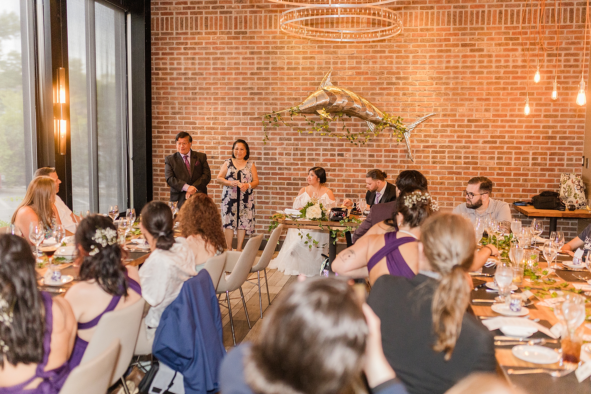 parents of bride and groom make a speech at wedding reception 