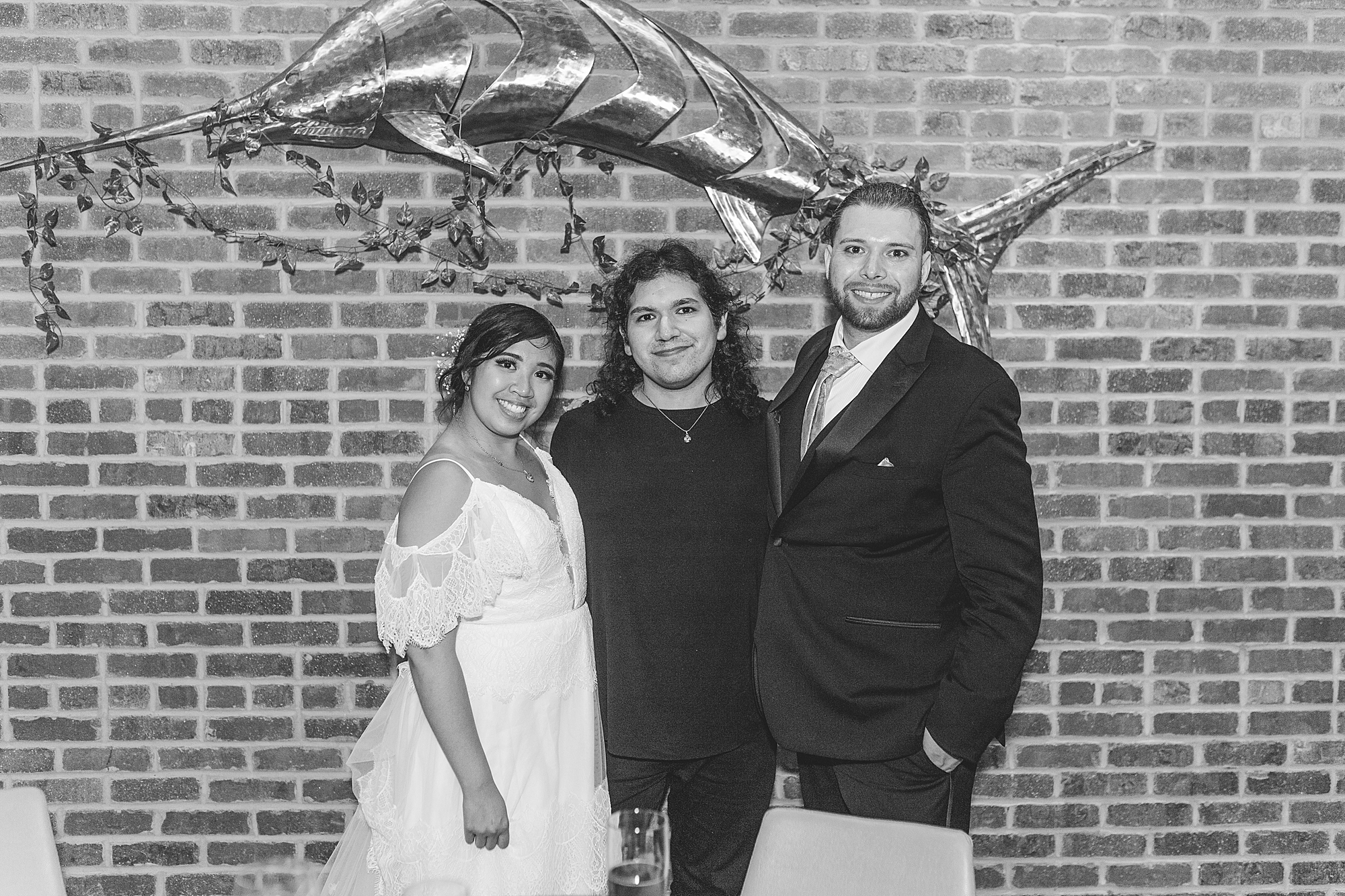 bride and groom taking a photo with wedding photographer at wedding reception 