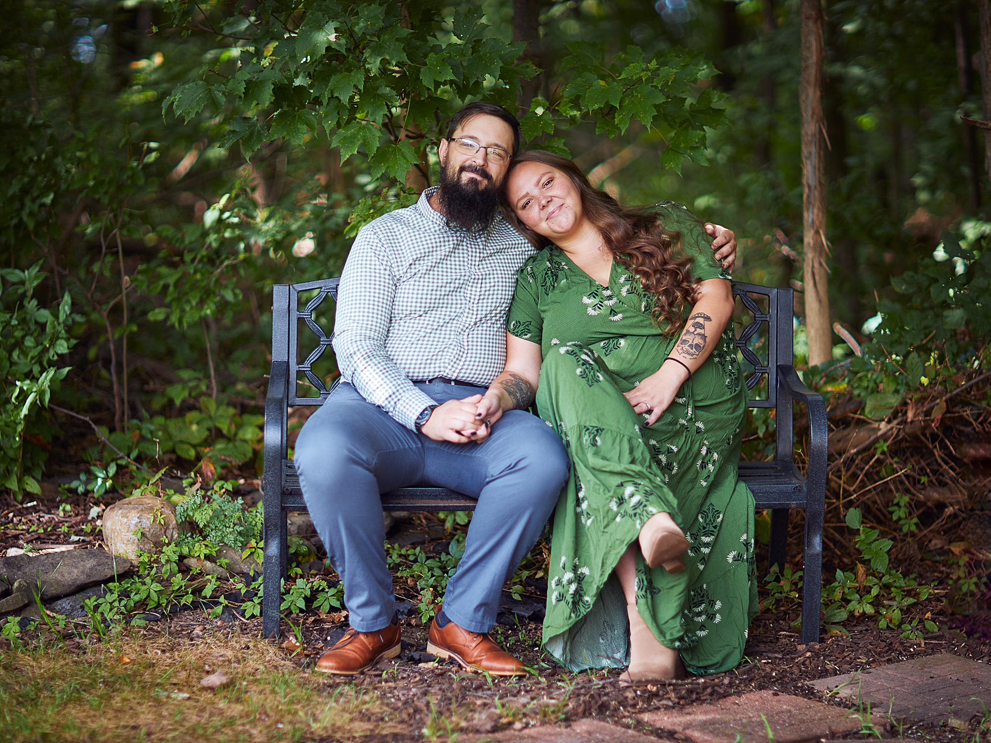 engaged couple holding hands sitting on a bench