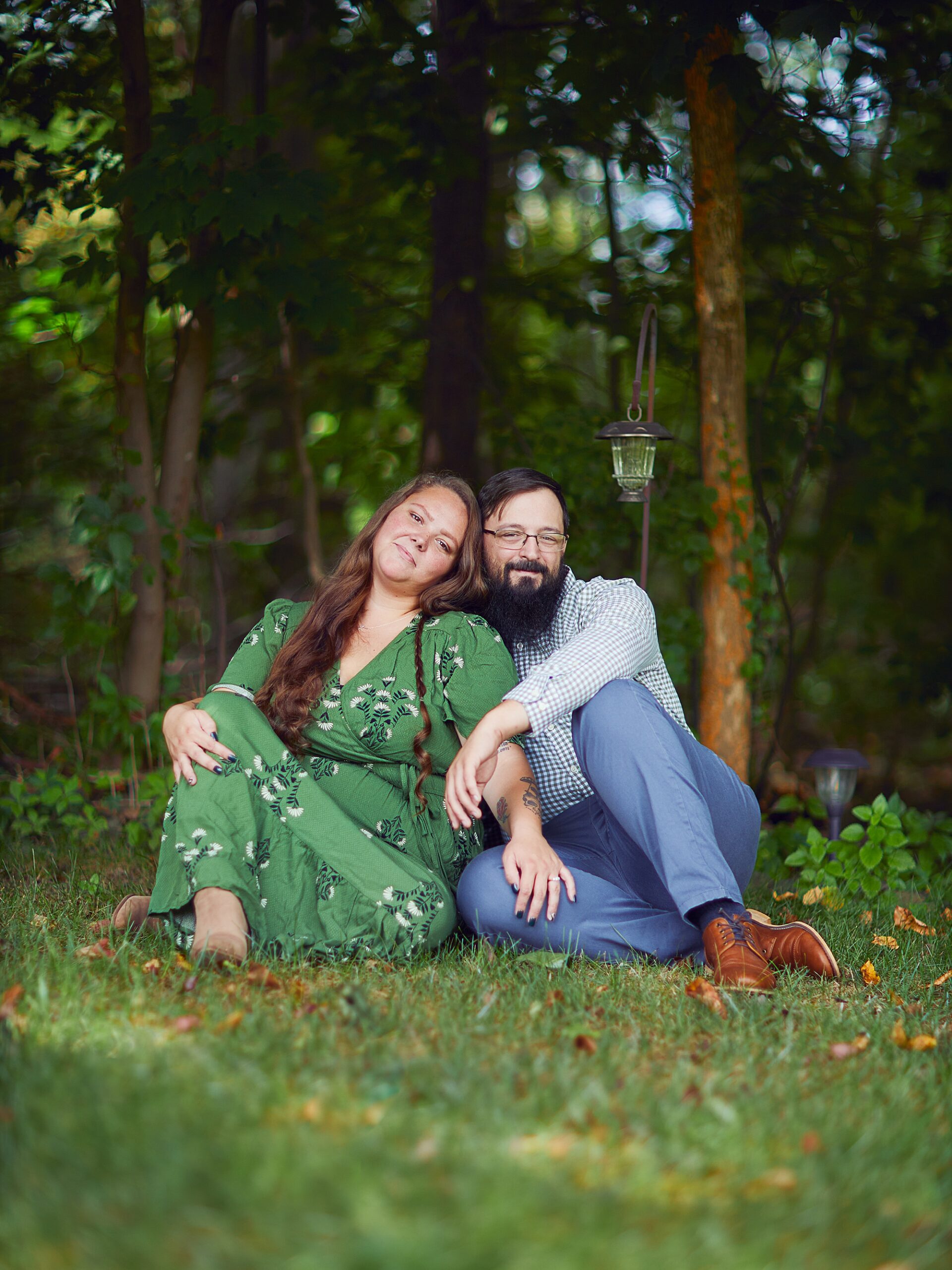 couple hugging each other and sitting on the grass