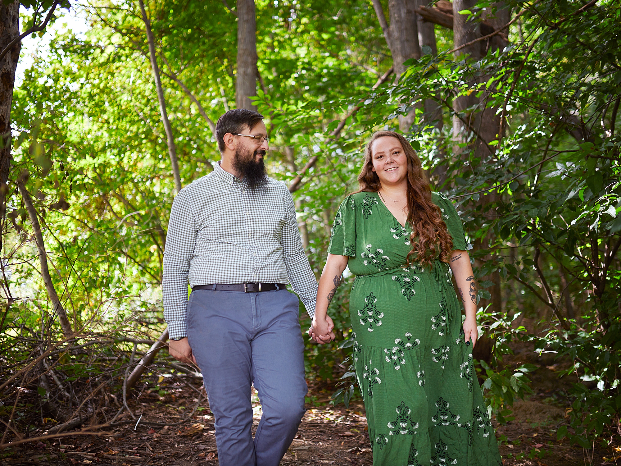 couple holdings hands walking in the forest