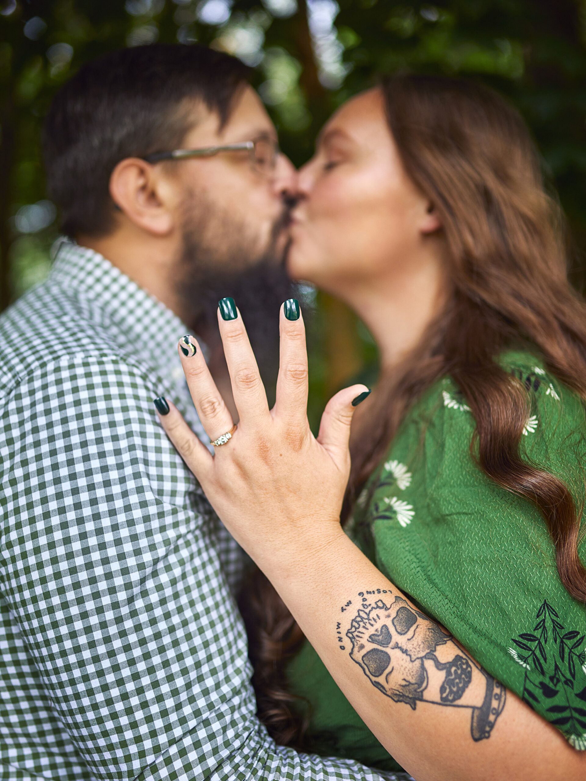 couple kissing and wearing engagement ring 