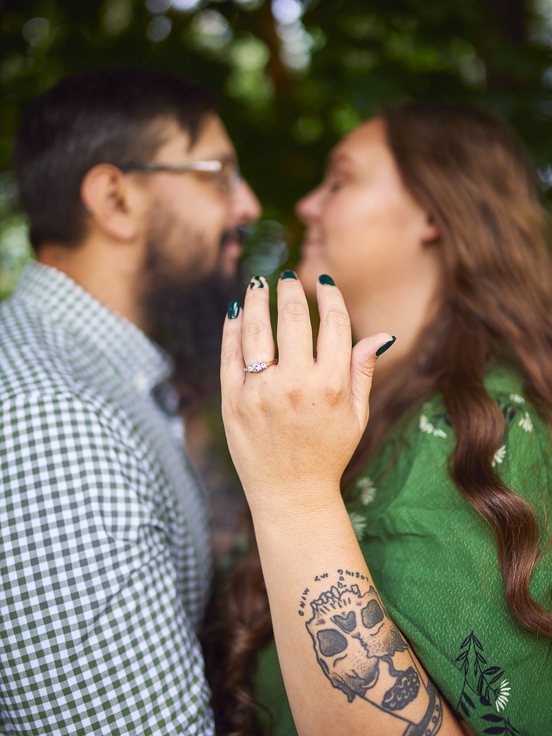 couple kissing and showing ring to camera