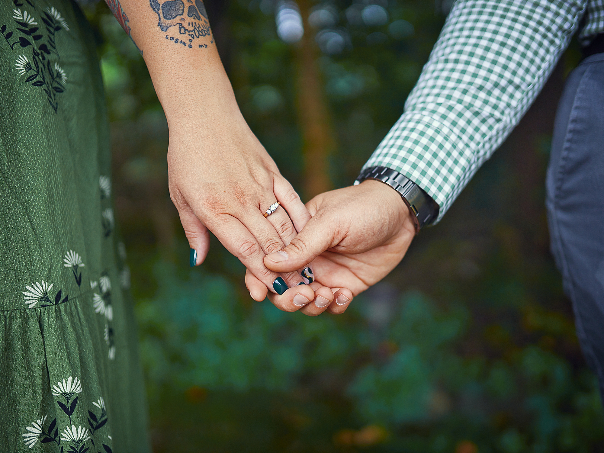 couple holding hands in forest 