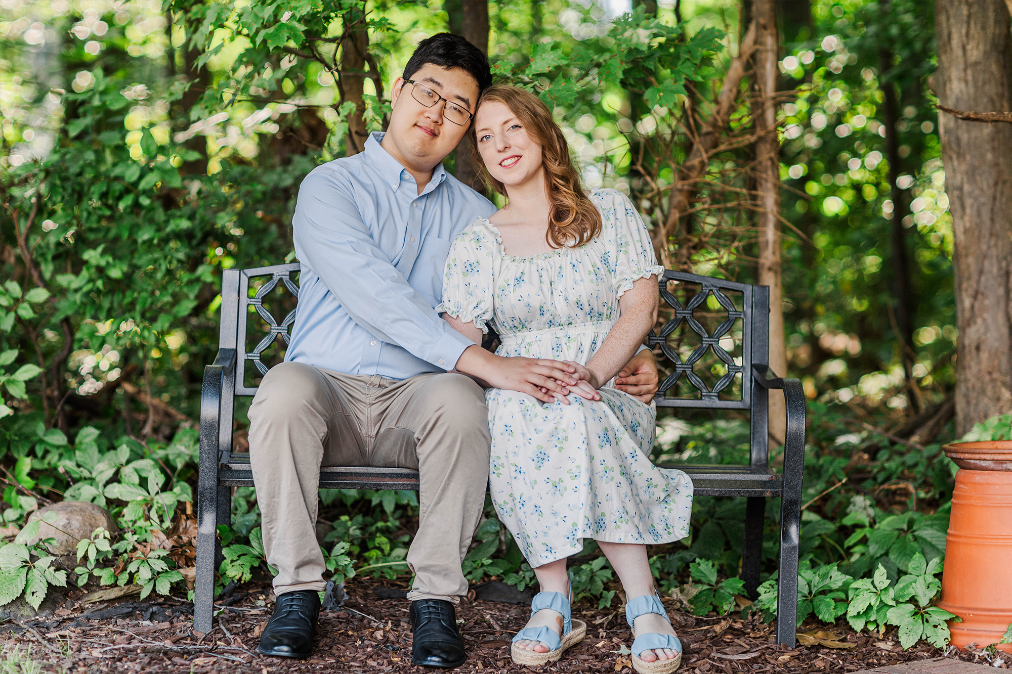 boyfriend and girlfriend holding hands on a bench 