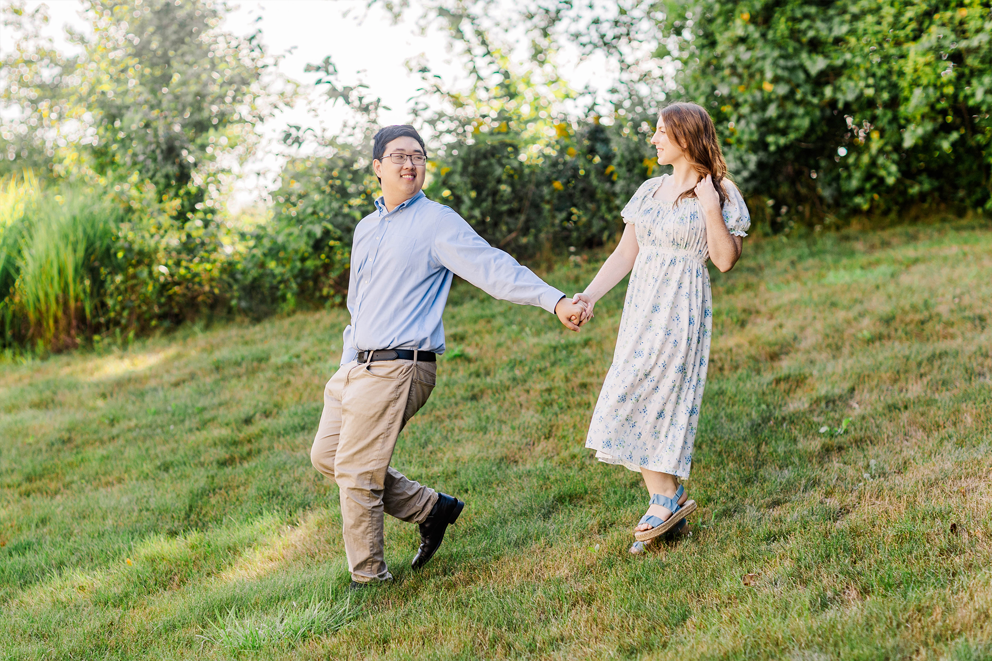 couple holding hands while walking down a hill 