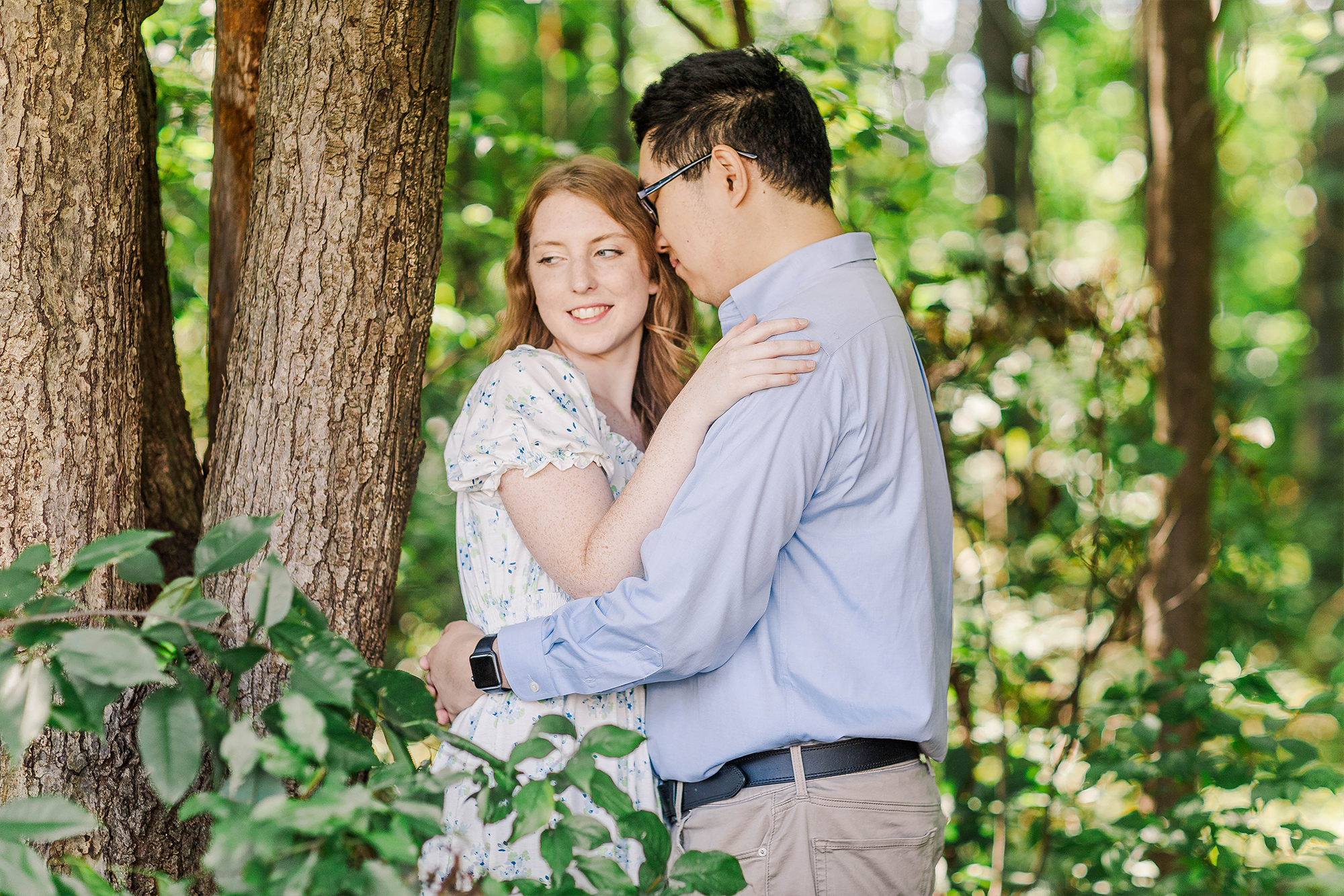 boyfriend and girlfriend hugging next to a tree