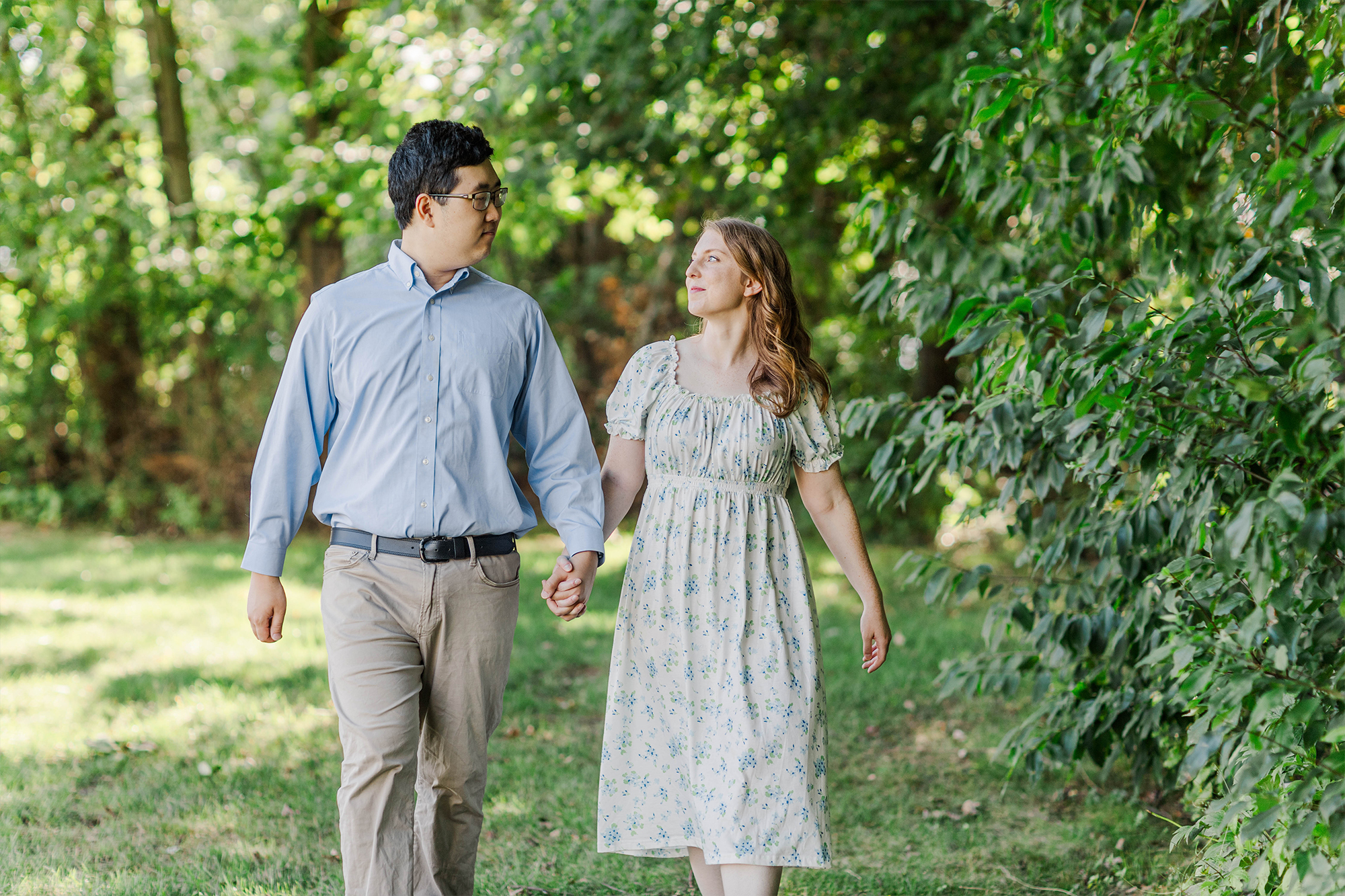 Couple holding hands while walking in grass