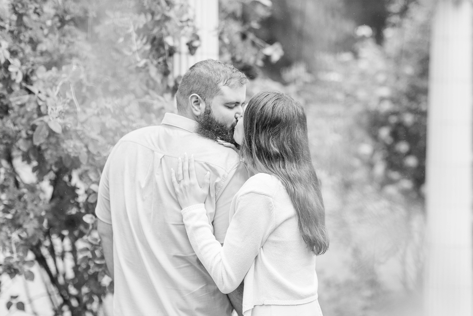 couple sharing kiss in greenery