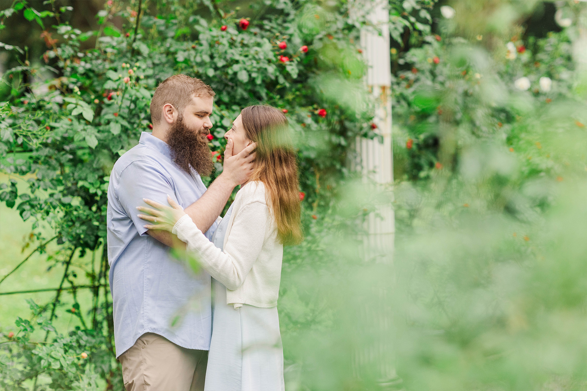 couple sharing a kiss next to roses