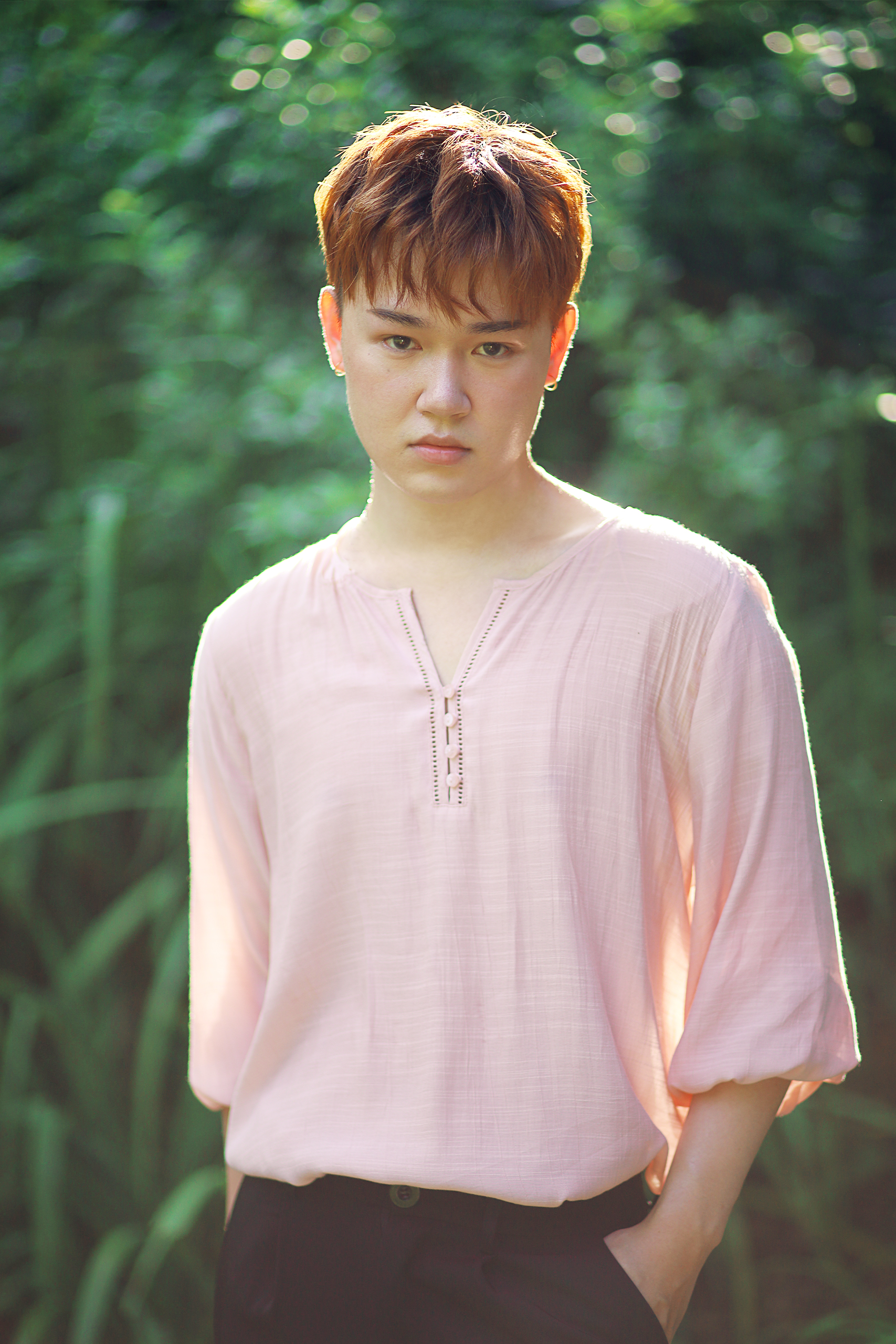man with loose pink shirt with greenery