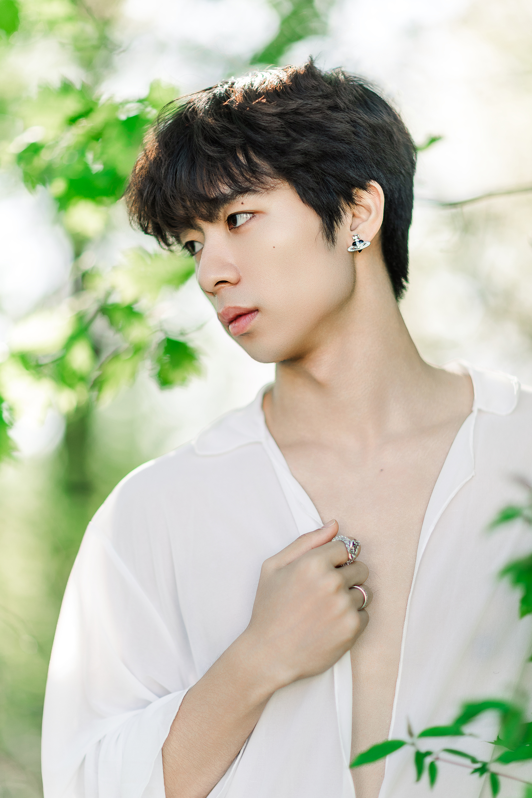 man with white shirt and jewelry with greenery