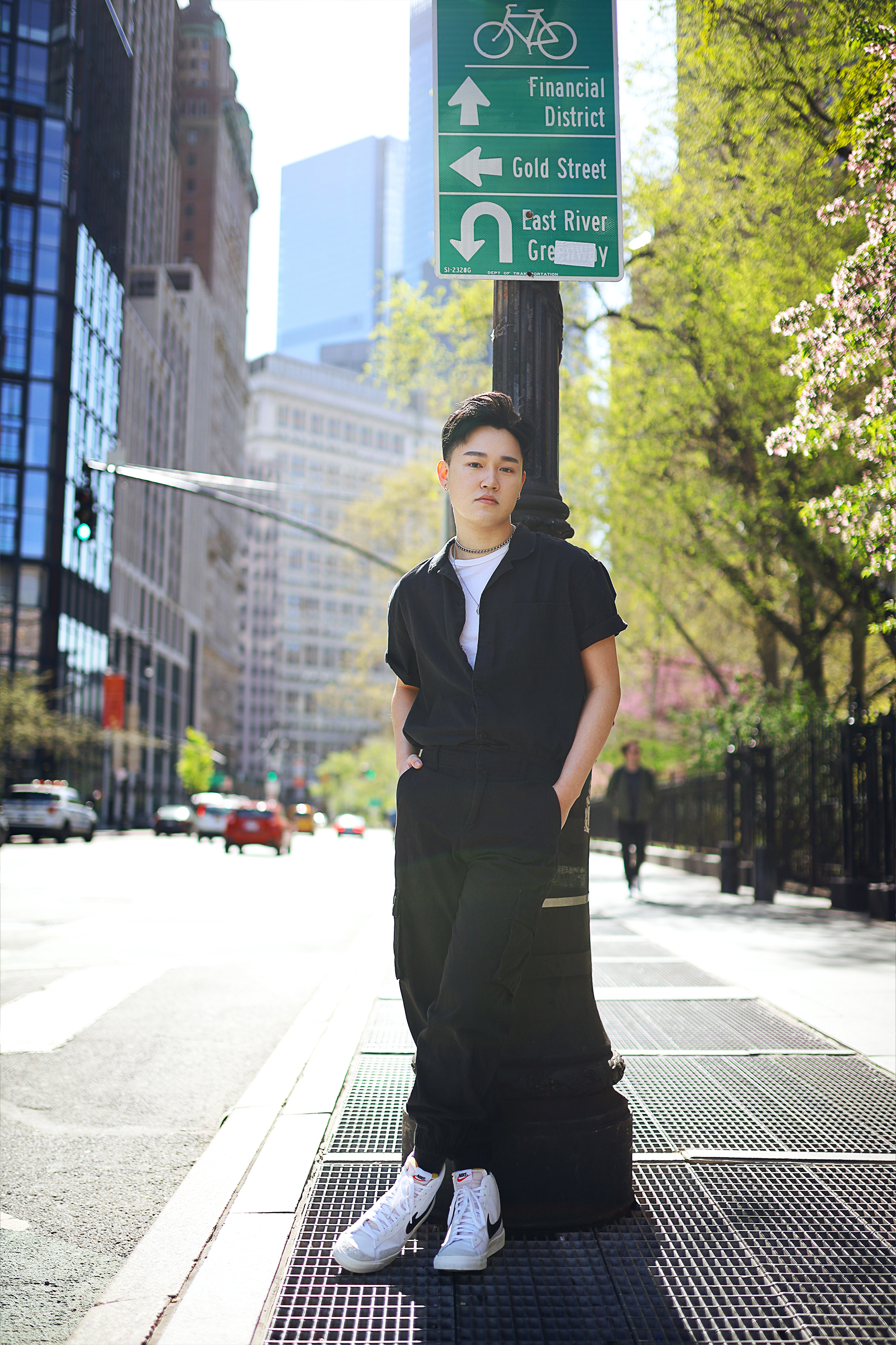 model leaning on street post in city