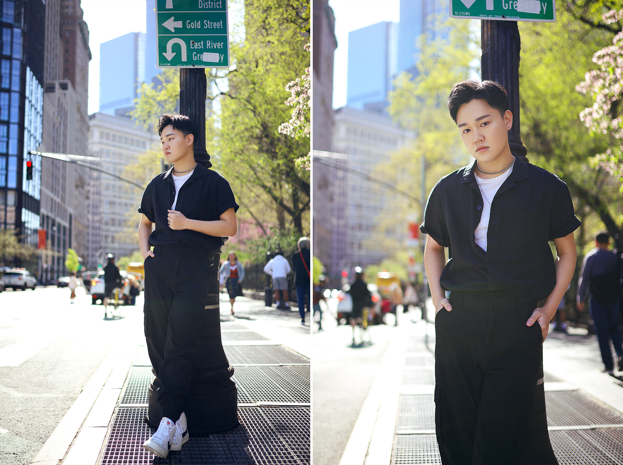 model leaning on lamp post with city and trees In background