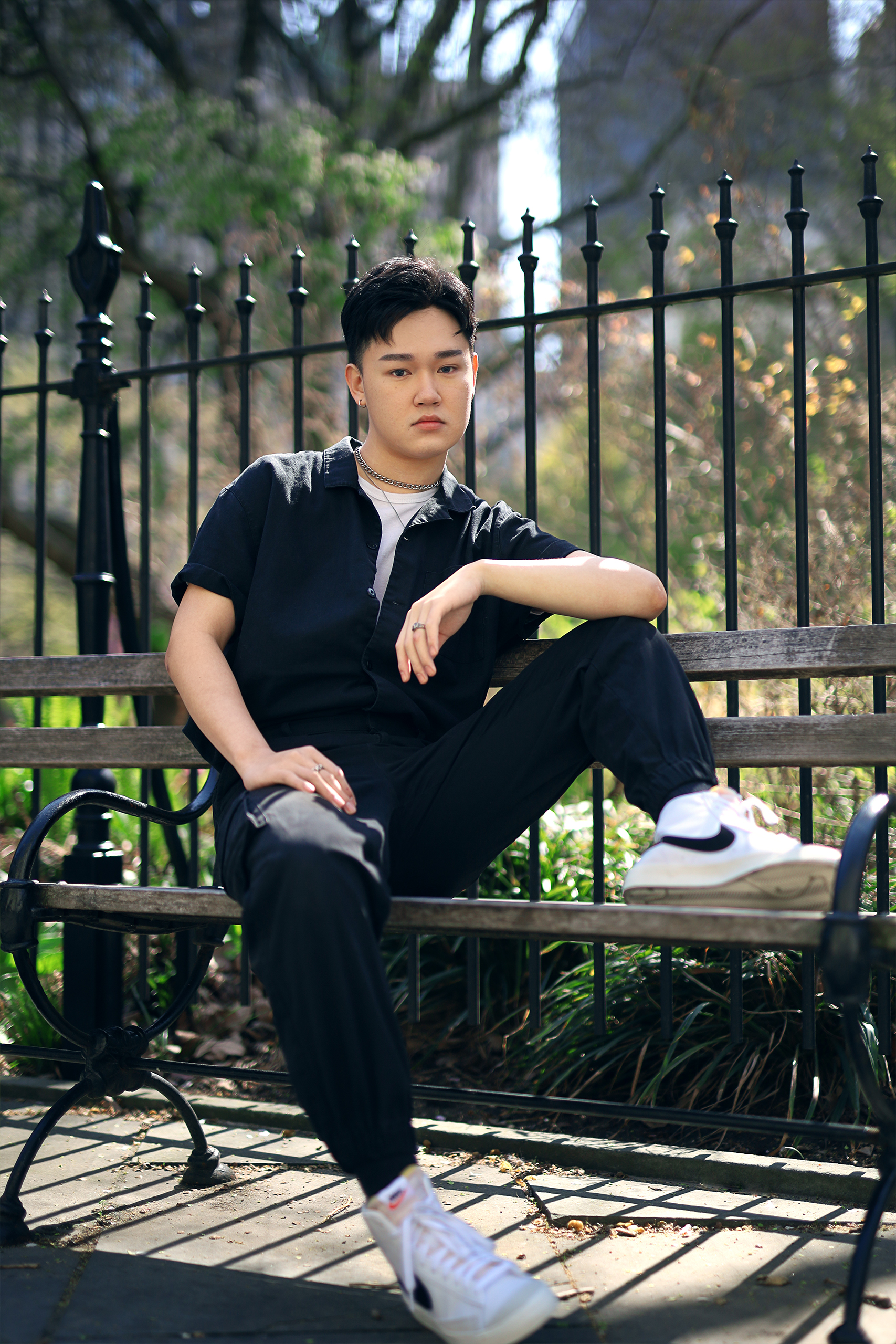 model sitting on bench in park