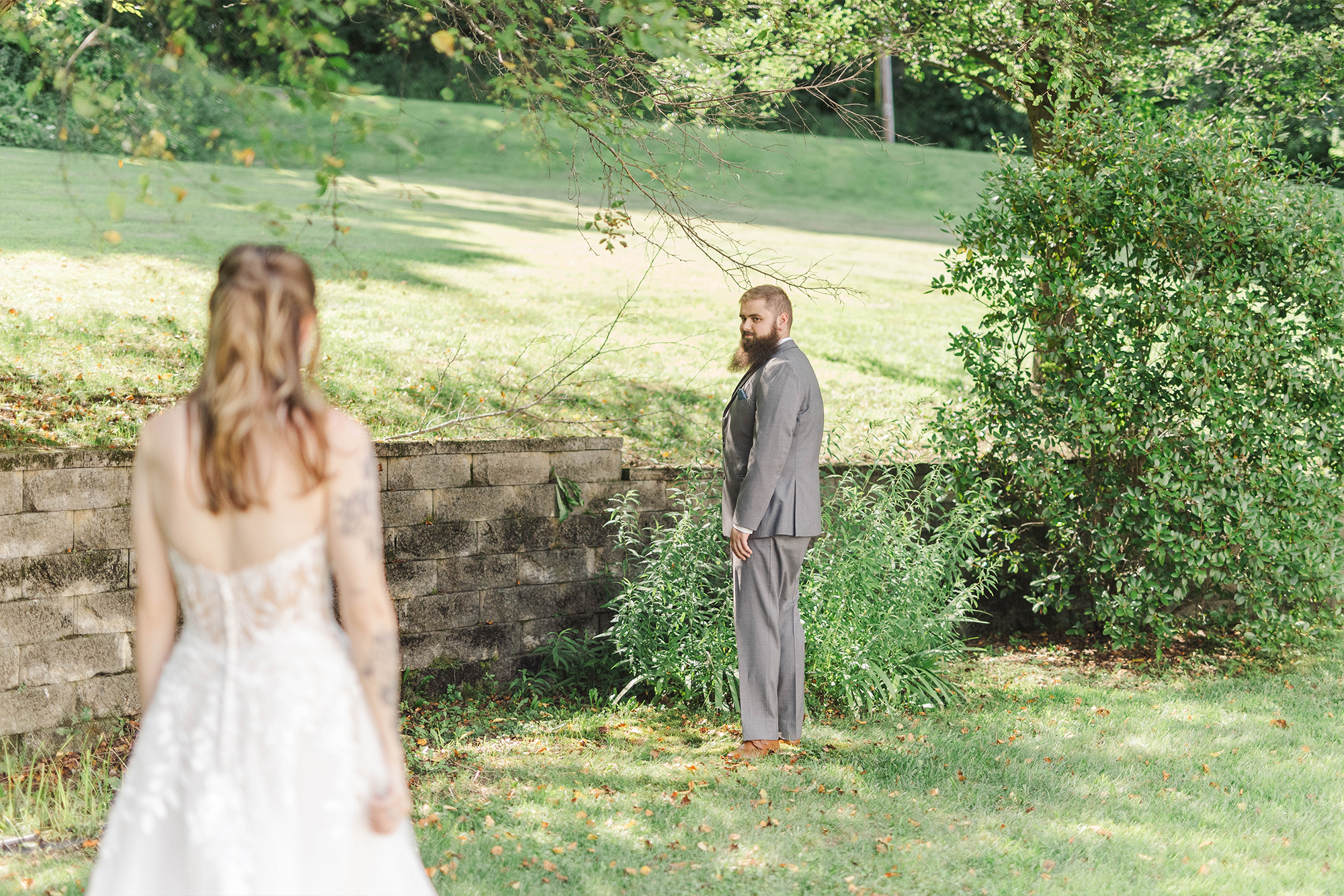 groom turning around to look at bride in backyard