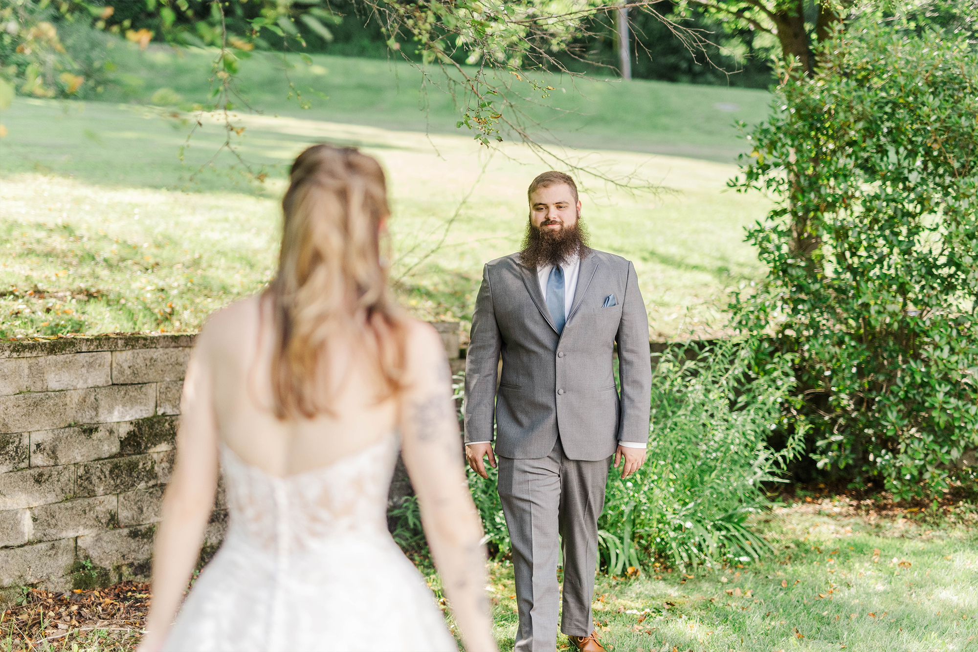 groom walking toward bride in backyard