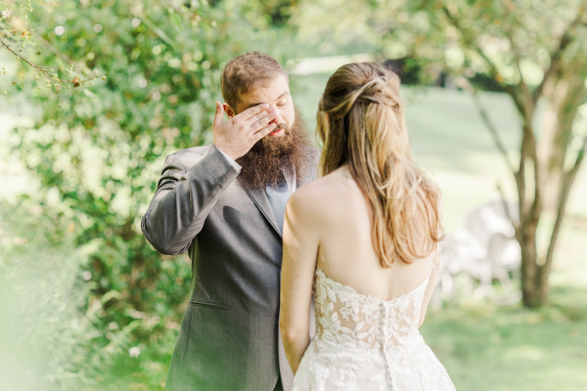 groom wiping face next to bride outdoors