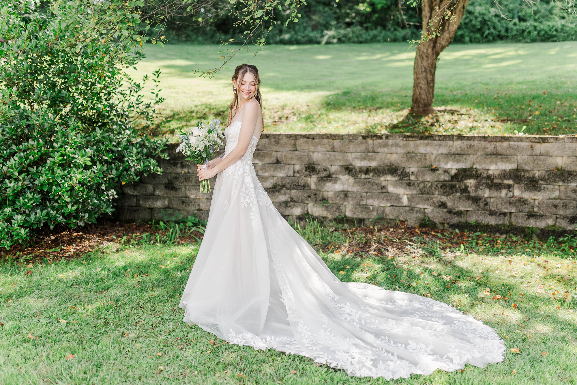 bride looking down at wedding dress train