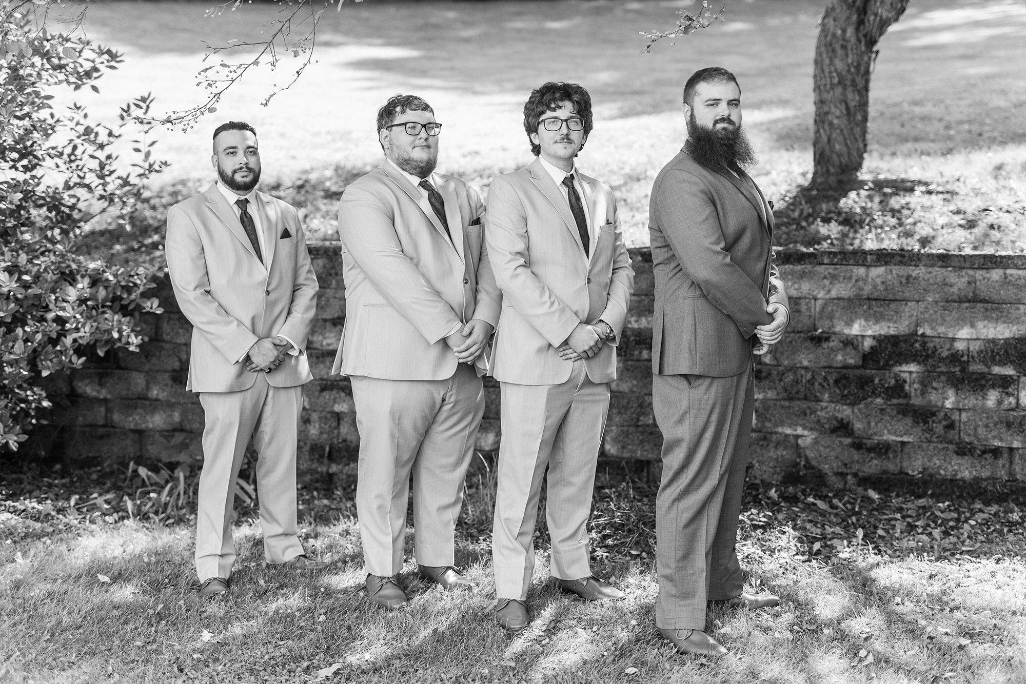 groomsmen posing under tree