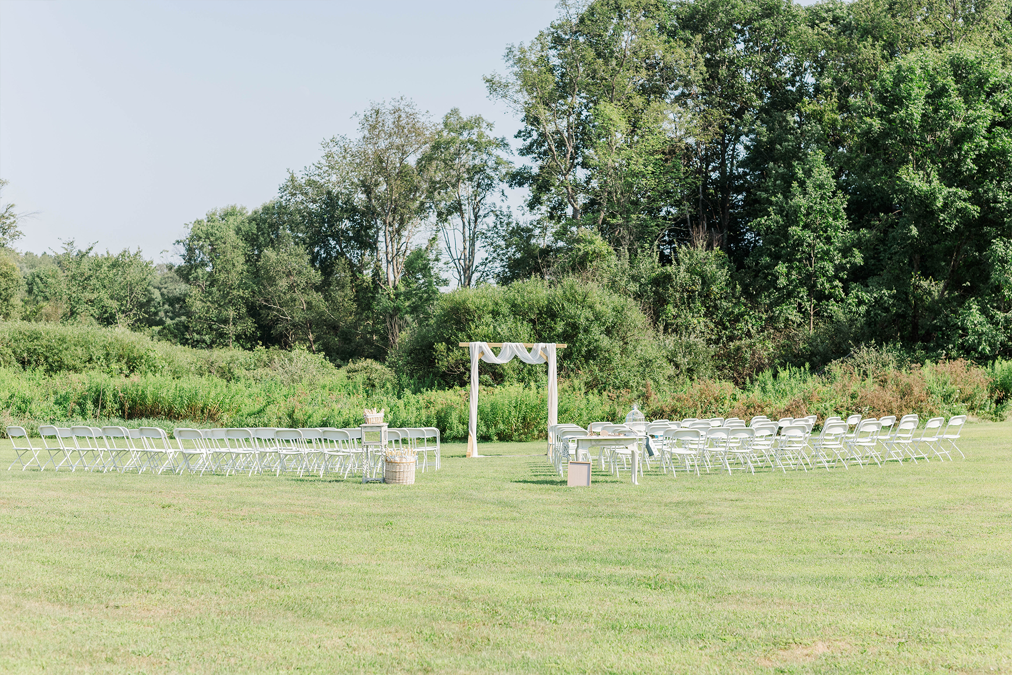 ceremony location with arch and seats with large trees