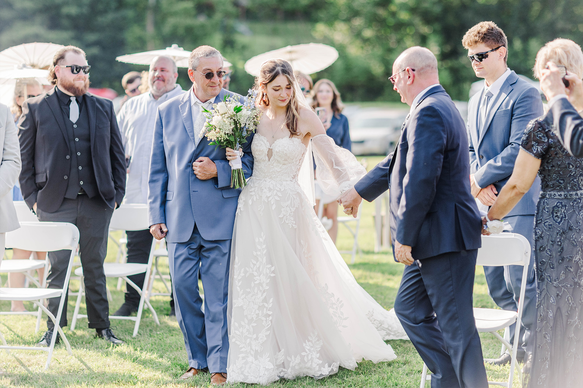 bride and father walking down aisle with greenery