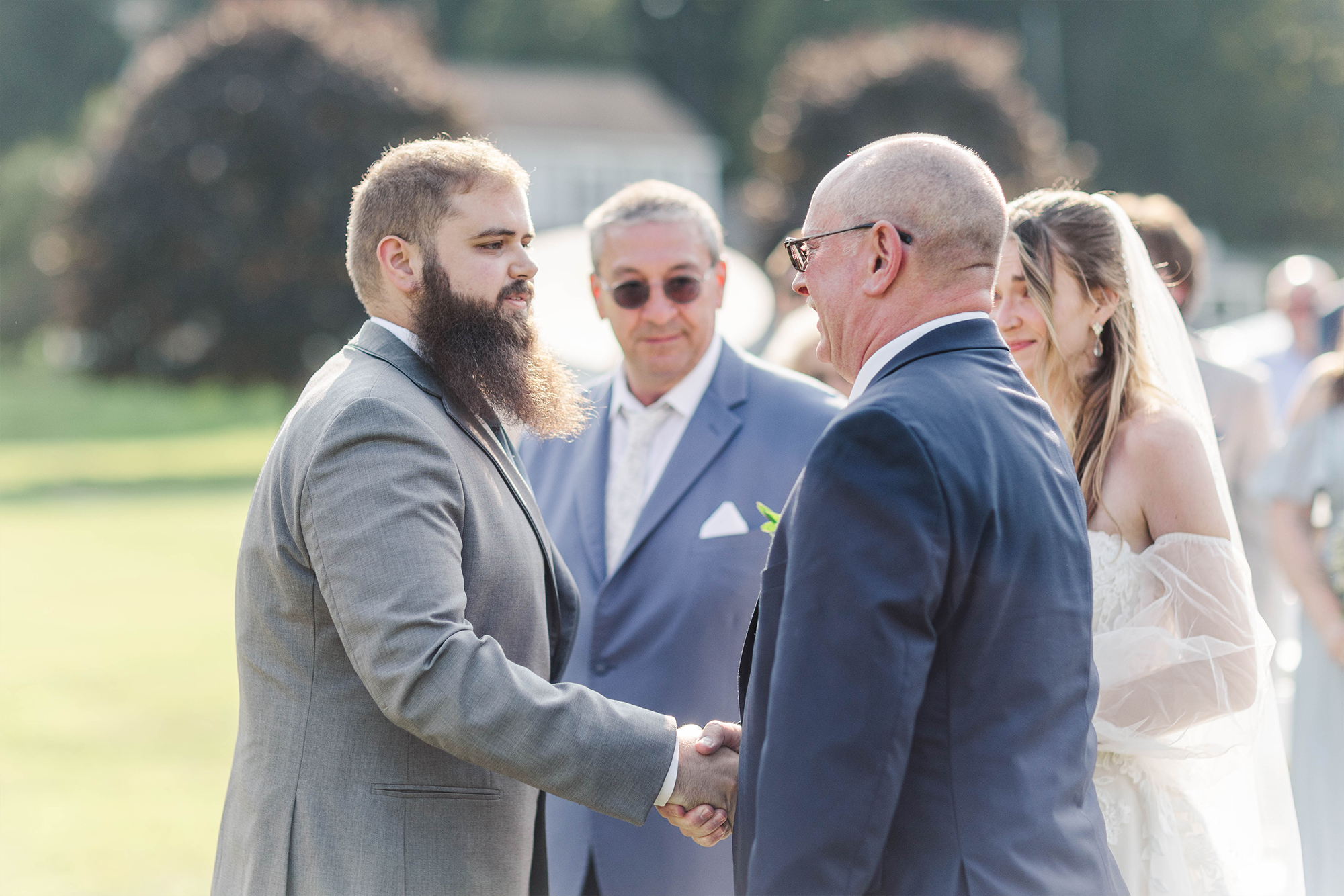 father and stepfather giving daughter away to groom