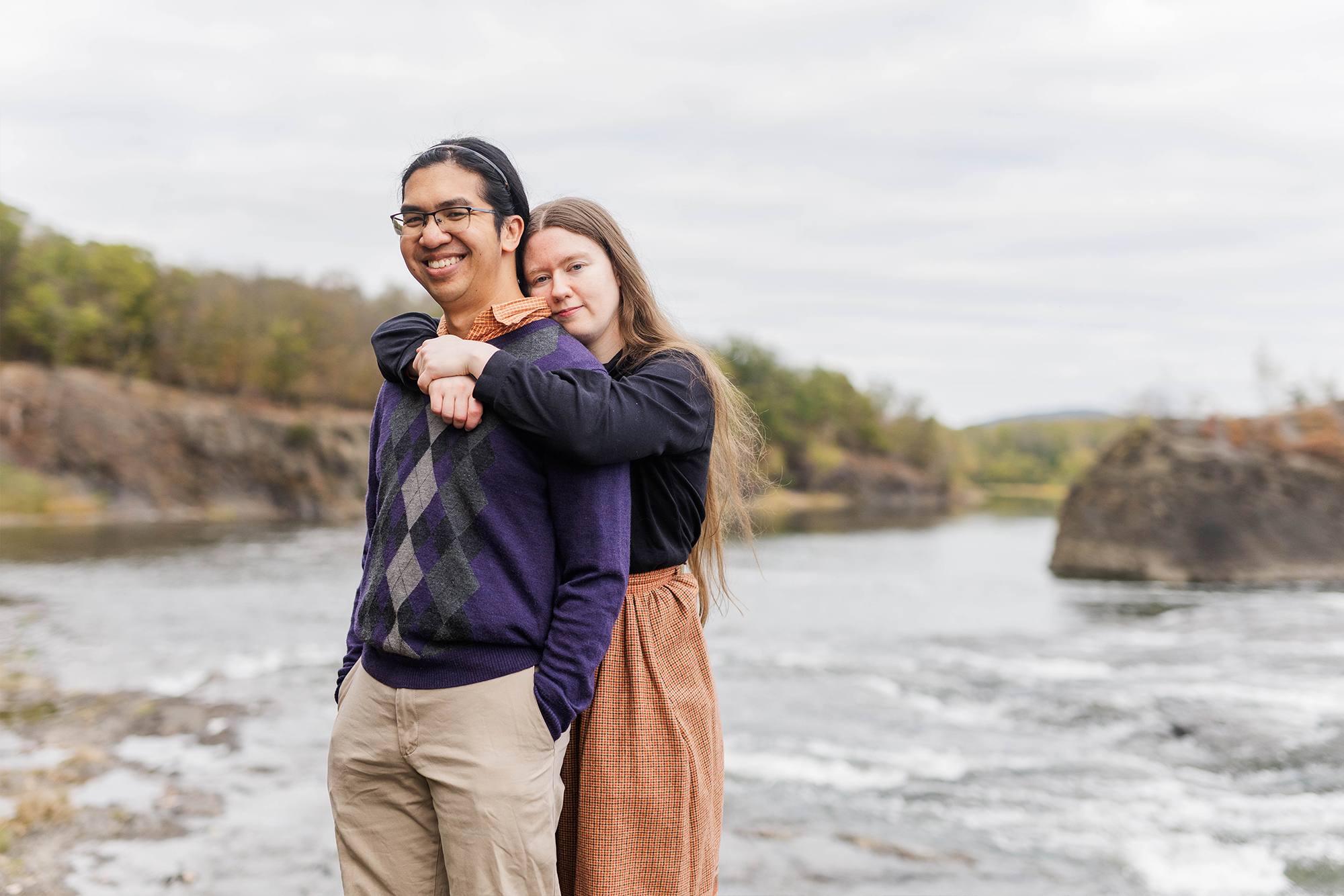 couple embracing each other near water