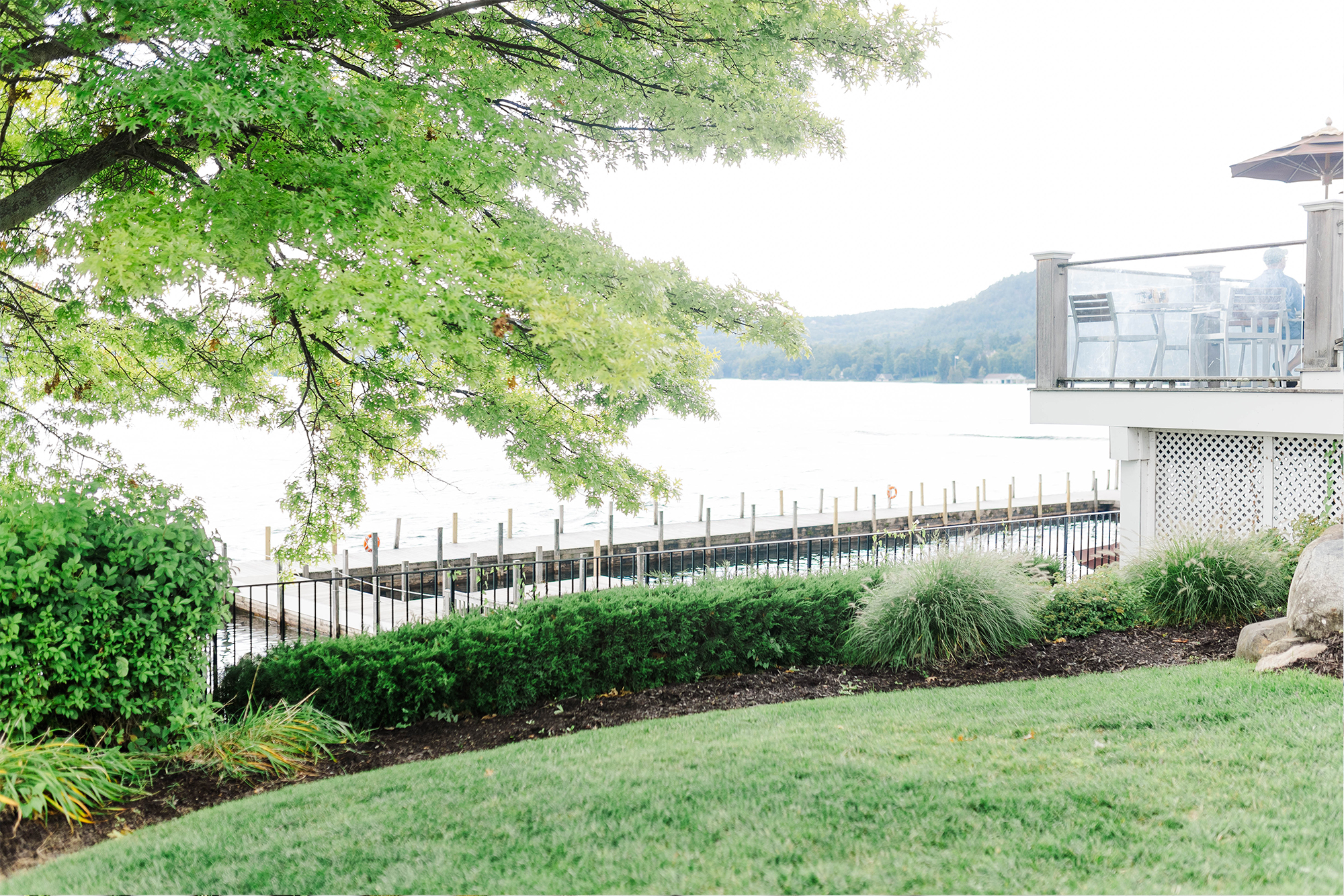 hill overlooking lake view with dock in bright sun