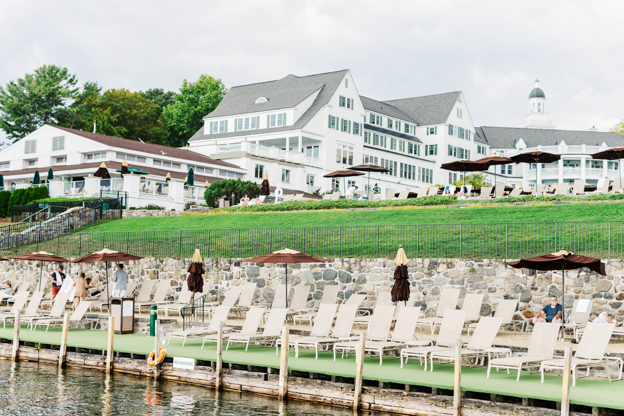view of hotel exterior with lounging chairs and umbrellas in front