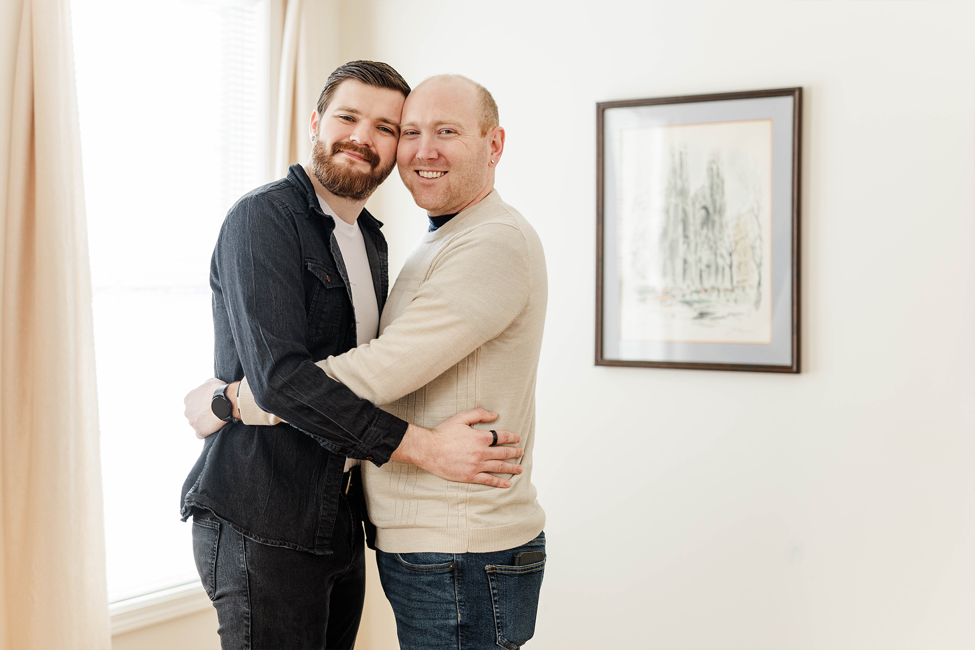 Man and Man holding each other in sun filled room