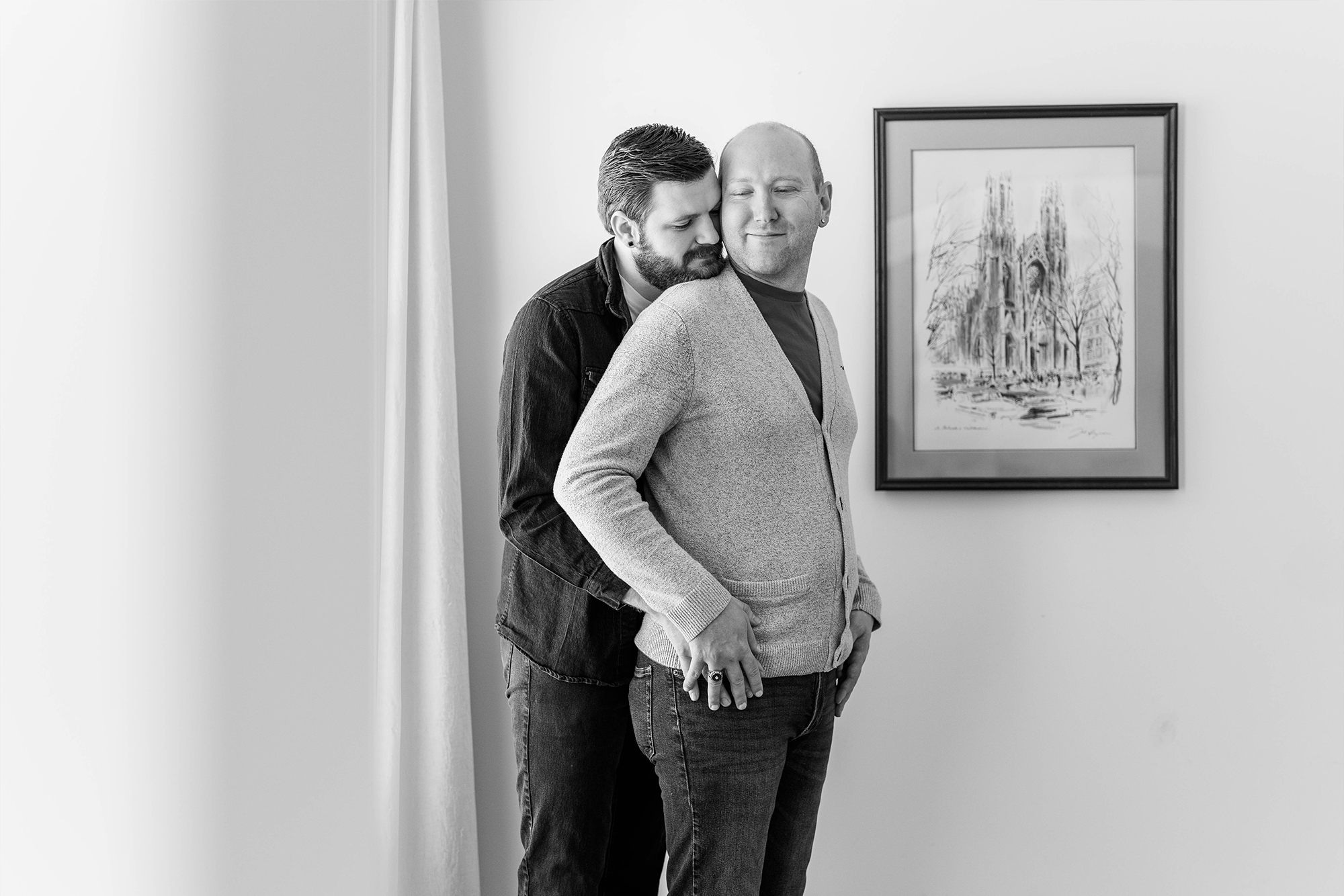 man holds his partner sharing a loving moment in middle of living room