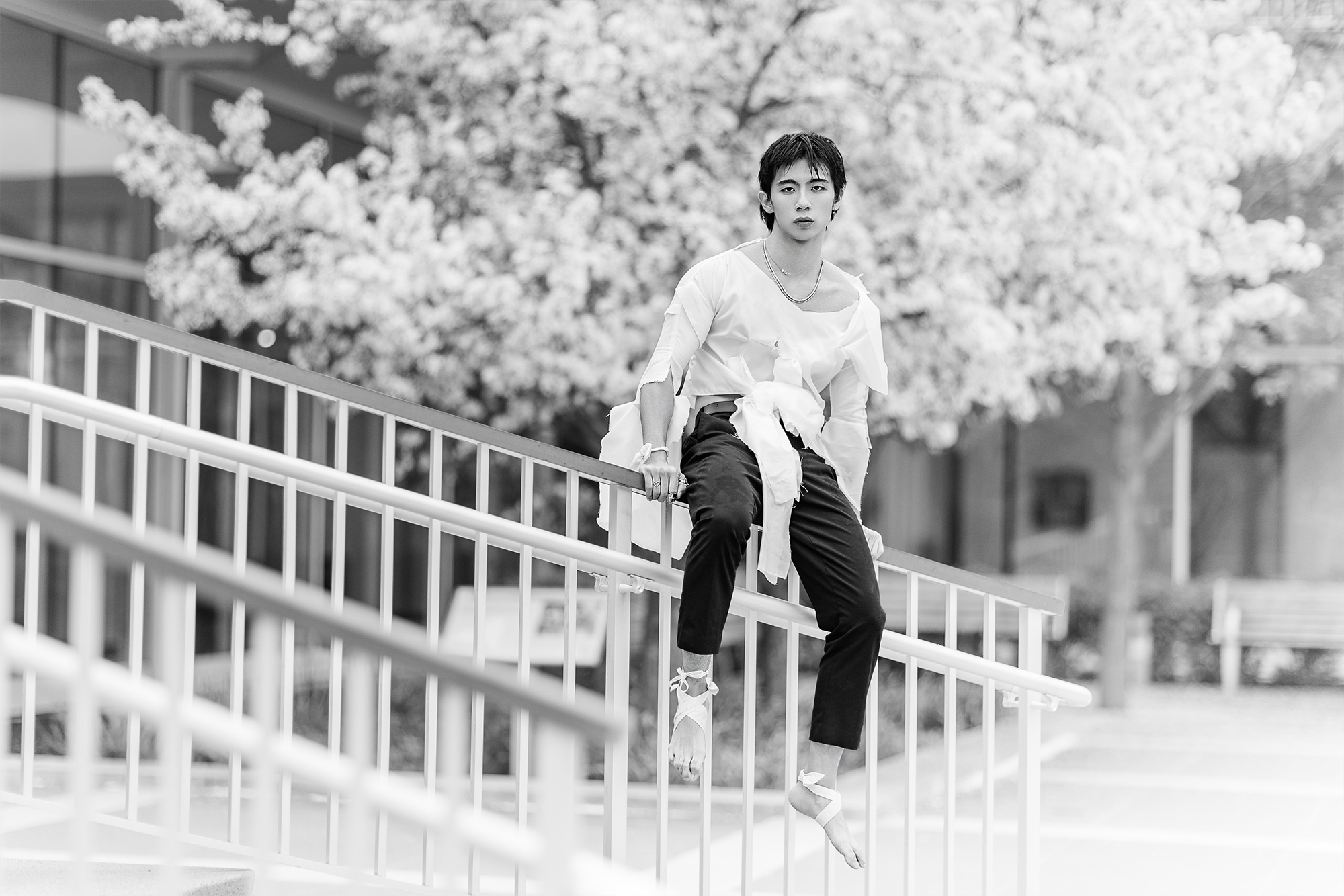man sitting on railing with torn clothing