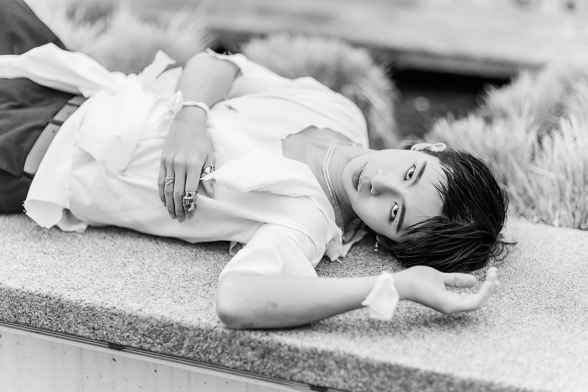 man laying down on stone ledge in school campus courtyard