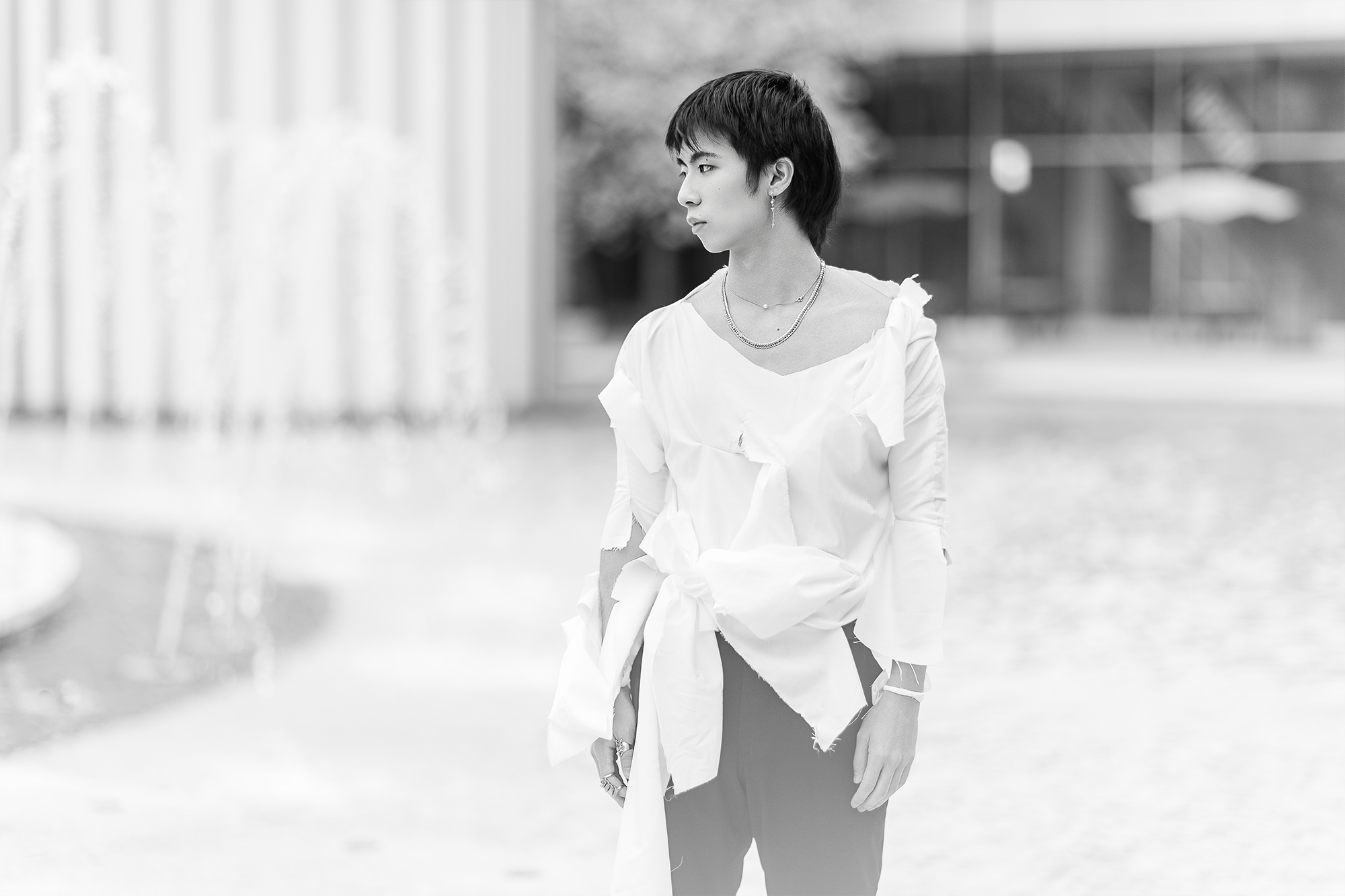 man looking into distance standing near water fountains