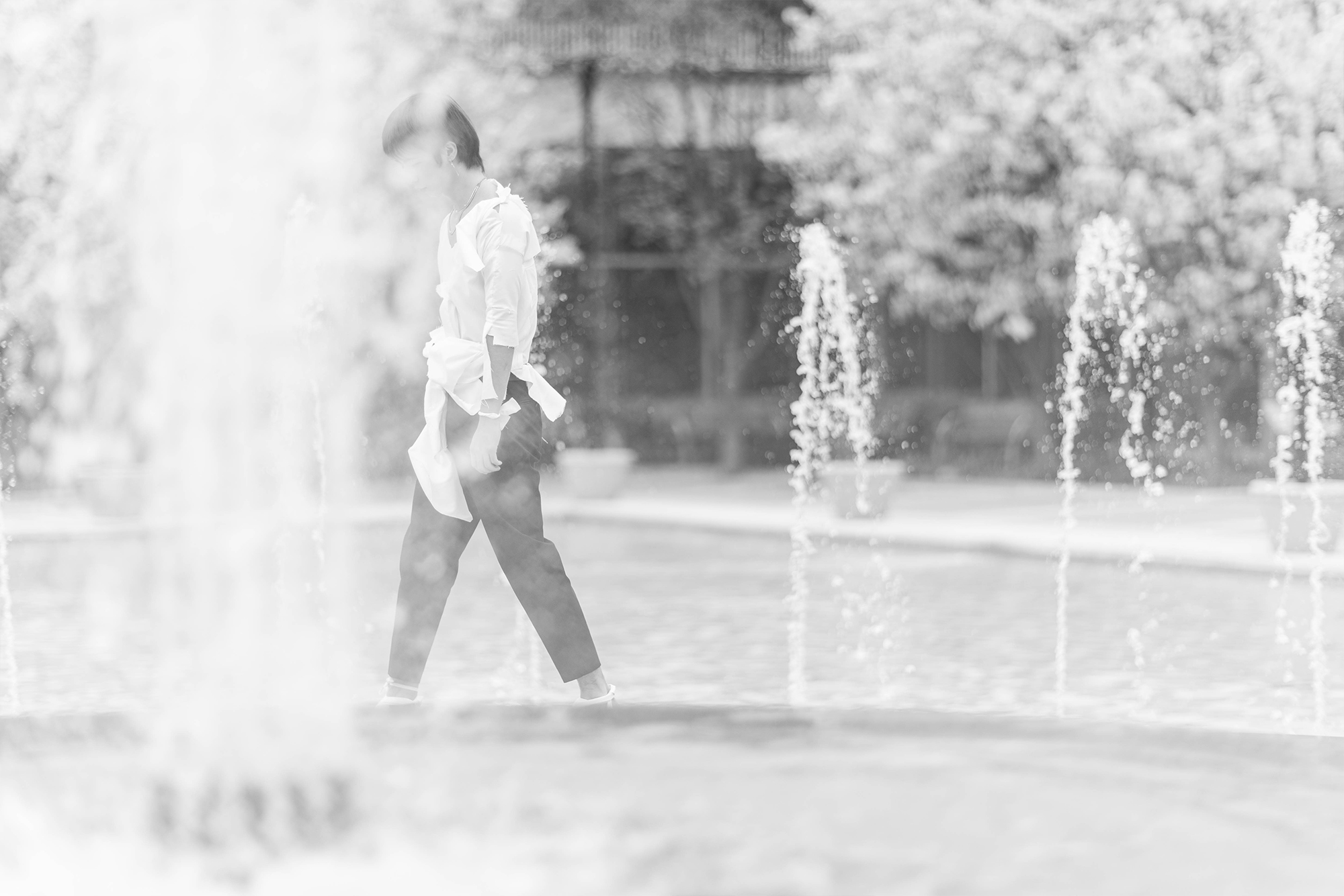 man walking through water fountains